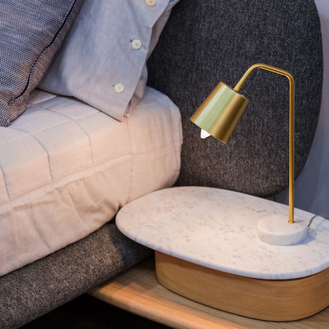 Gold brass lamp on bedside table decor in the interior.